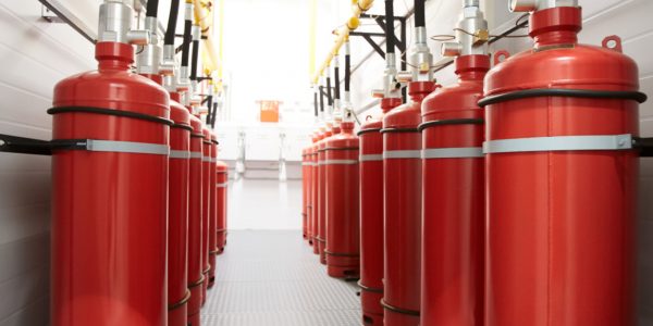 Background image of narrow corridor of industrial room with air tanks connected to metal tube, fire-extinguishing appliance